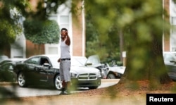 A woman expresses her frustration toward reporters and photographers at a news conference held at The Village at College Downs apartment complex the morning after the police shooting of Keith Lamont Scott, in Charlotte, N.C., Sept. 21, 2016.