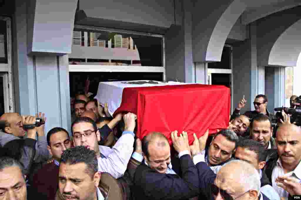 The body of slain Police Brigadier General Tariq al-Mirjawi is carried out of the Agouza Police Hospital after a series of explosions hit Cairo University, Cairo, Egypt, April 2, 2012. (Hamada Elrasam for VOA)