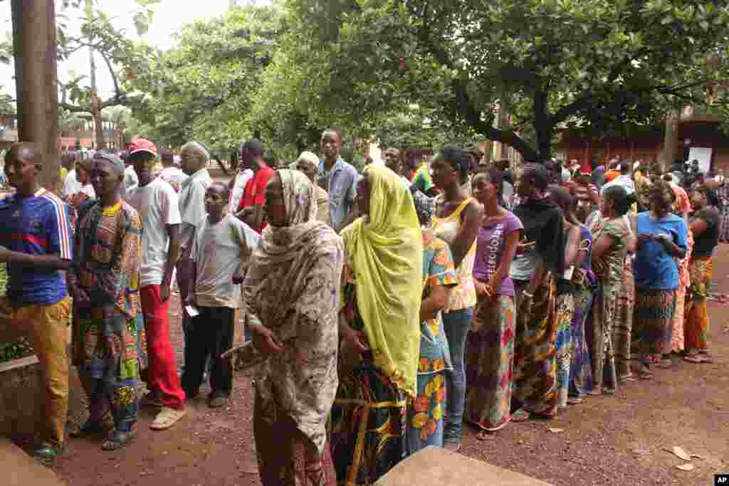 Men and women wait in separate lines to cast their votes in legislative elections, at a polling station in Conakry, Guinea, Sept. 28, 2013. 