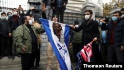 이란 핵 과학자 암살 사건에 분노한 이란인들이 28일 이스라엘 국기와 미국 성조기를 불태우고 있다.