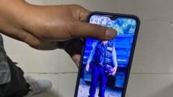 Tha Peng, a Myanmar national who said he was a police officer and recently fled to India shows his photograph in his phone wearing a police uniform following his interview with Reuters at Champhai town in India's northeastern state of Mizoram near the Ind