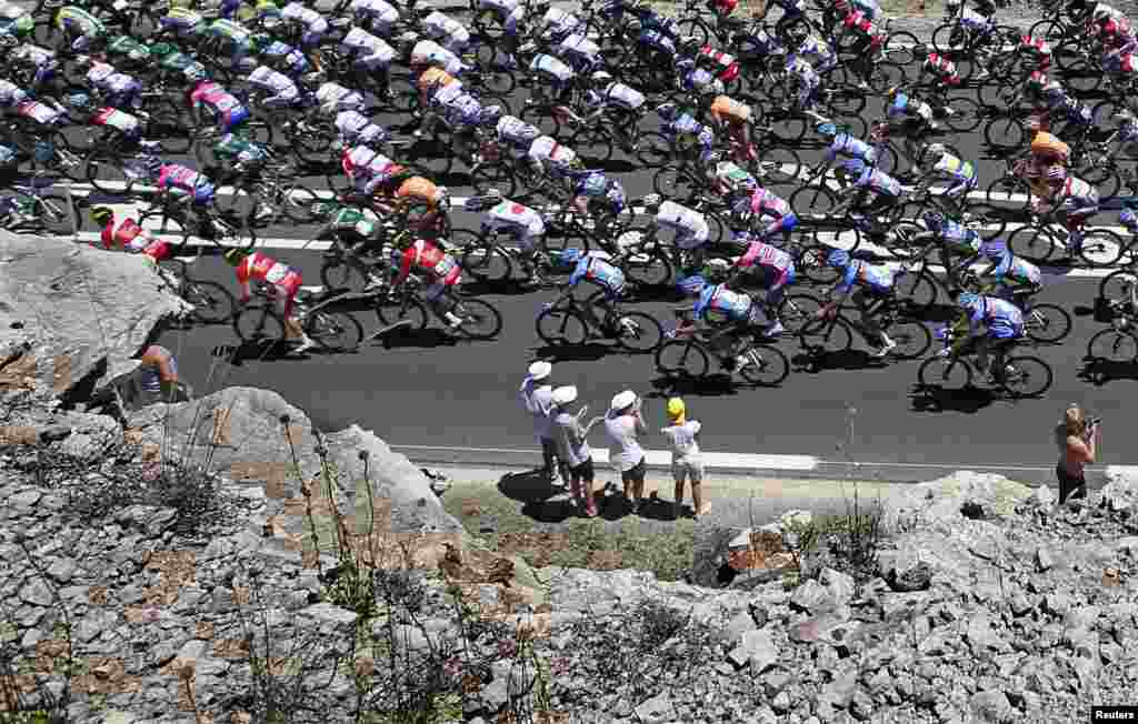 Fans watch as a pack of riders cycles past during the 205.5 km seventh stage of the centenary Tour de France from Montpellier to Albi.