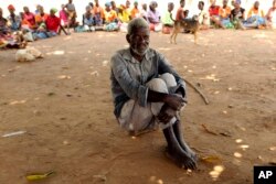 A man waits to receive food aid outside a camp for displaced survivors of cyclone Idai in Dombe, Mozambique, April 4, 2019.
