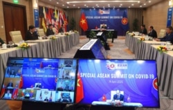 FILE - Vietnamese Prime Minister Nguyen Xuan Phuc, background, addresses ASEAN leaders during the Special ASEAN summit on COVID-19 in Hanoi, Vietnam, April 14, 2020.