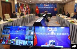 FILE - Vietnamese Prime Minister Nguyen Xuan Phuc, background, addresses ASEAN leaders during the Special ASEAN summit on COVID-19 in Hanoi, Vietnam, April 14, 2020.