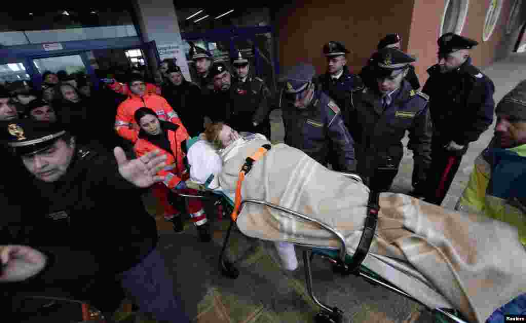 Medics transport a wounded woman from the " Spirit of Piraeus" cargo container ship as they arrive in Bari harbour, after the car ferry Norman Atlantic caught fire in waters off Greece, Dec. 29, 2014.