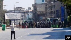 A protester faces riot police at Khalidia, near Homs, Syria November 4, 2011.