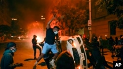 Người biểu tình đập phá một chiếc xe gần Tòa Bạch Ốc tối ngày 31/5/2020.