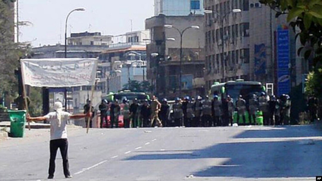 A protester faces riot police at Khalidia, near Homs, Syria November 4, 2011.