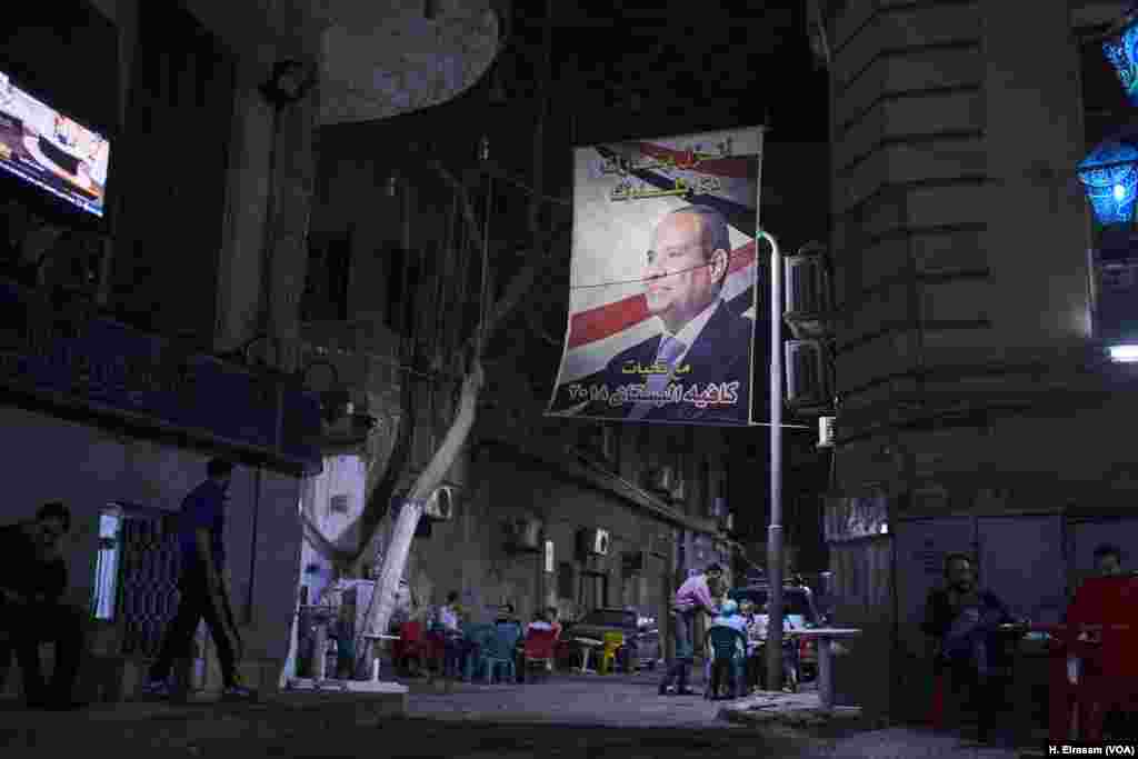 A campaign poster left over from the March election hangs over a café in central Cairo. El-Sissi ran largely uncontested and secured an easy victory thanks in part to good economic numbers.