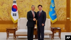 韩国总统李在明在首尔总统办公室与来访的中国外长王毅握手合影。(2026年9月30日)