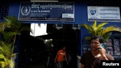 FILE - A man on the phone in front of the office of the Cambodian League for the Promotion and Defense of Human Rights (LICADHO), in Phnom Penh, Cambodia