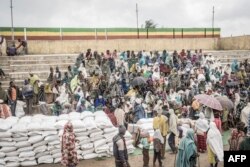 People who fled the war from May Tsemre, Addi Arkay and Zarima gather around in a temporarily built internally displaced people (IDP) camp to receive their first bags of wheat from the World Food Program in Debark, 90 kilometers of the city of Gondar, Ethiopia, Sept. 15, 2021.
