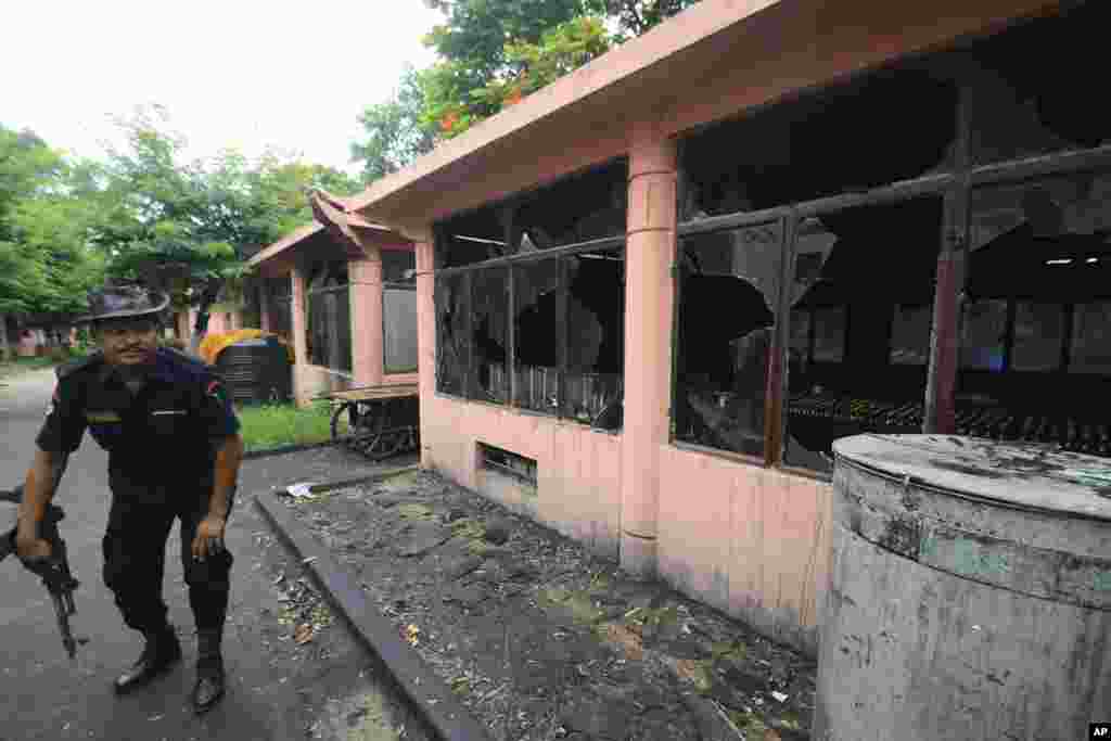 A security officer inspects the site of an explosion on the campus of the Mahabodhi Temple, the Buddhist Great Awakening temple, in Bodhgaya, Bihar, India, July 7, 2013.