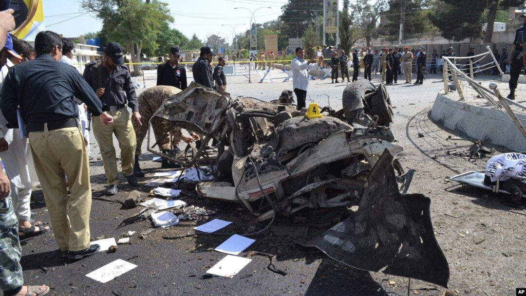 Pakistani police officers examine the site of an explosion in Quetta, Pakistan, June 23, 2017. A powerful bomb went off near the office of the provincial police chief in southwest Pakistan, causing casualties, police said.