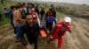 Medics and protesters evacuate a youth who was shot by Israeli troops near the Gaza Strip's border with Israel while marking first anniversary of Gaza border protests east of Gaza City, March 30, 2019.