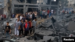 Palestinians inspect damage in the aftermath of Israeli strikes, at Beach refugee camp, in Gaza City, Oct. 9, 2023.