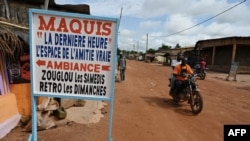 Des habitants roulent à moto dans le quartier "carrefour" de Duekué, dans l'ouest de la Côte d'Ivoire, le 9 octobre 2020.