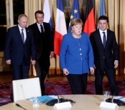 French President Emmanuel Macron, second left, Russian President Vladimir Putin, left, German Chancellor Angela Merkel and Ukrainian President Volodymyr Zelenskiy gather for talks at the Elysee Palace, in Paris, France, Dec. 9, 2019.