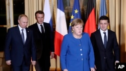 French President Emmanuel Macron, second left, Russian President Vladimir Putin, left, German Chancellor Angela Merkel and Ukrainian President Volodymyr Zelenskiy gather for talks at the Elysee Palace, in Paris, France, Dec. 9, 2019.