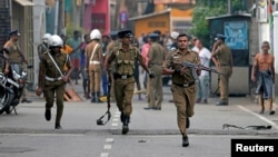 Polisi Sri Lanka mensterilkan kawasan saat Gugus Tugas Khusus Pasukan Penjinak Bom memeriksa lokasi dari mobil van yang meledak dekat gereja yang diserang di Kolombo, Sri Lanka, 22 April 2019 (foto: Reuters/Dinuka Liyanawatte)