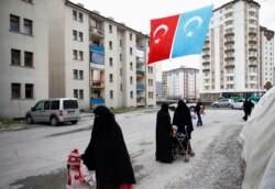 FILE - Uyghur refugee women walk where they are housed in a gated complex in the central city of Kayseri, Turkey, February 11, 2015.