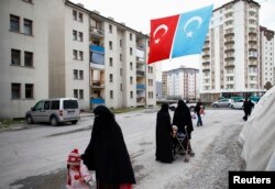FILE - Uyghur refugee women walk where they are housed in a gated complex in the central city of Kayseri, Turkey, February 11, 2015.