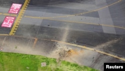 La vista aérea tomada desde un helicóptero muestra un cráter de una explosión después de que estallara una bomba de la Segunda Guerra Mundial, en una calle de rodaje del aeropuerto de Miyazaki.