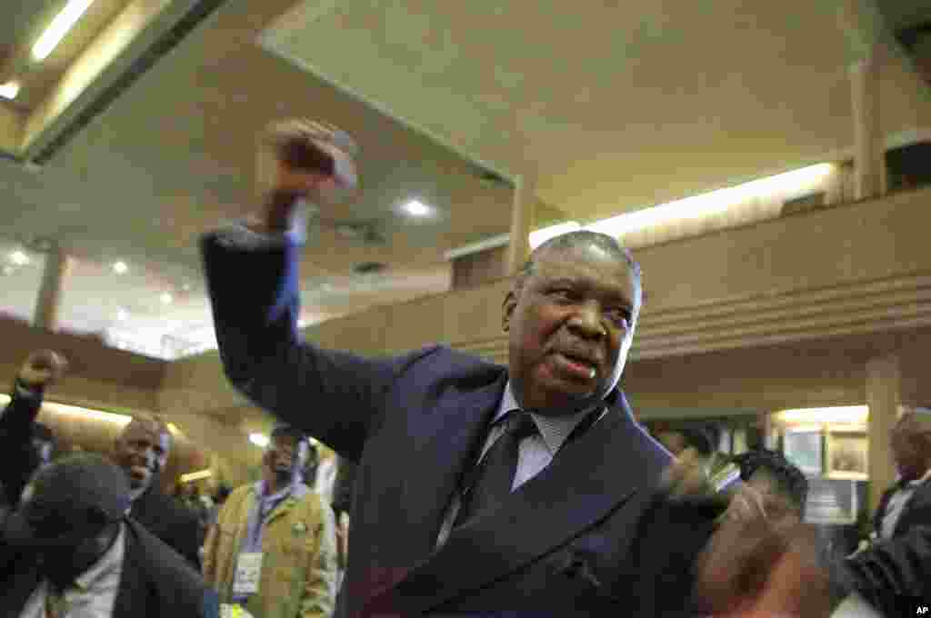 Phelekezela Mphoko scande le slogan de son parti au siège de la Zanu PF à Harare, mercredi 10 décembre&nbsp;2014.