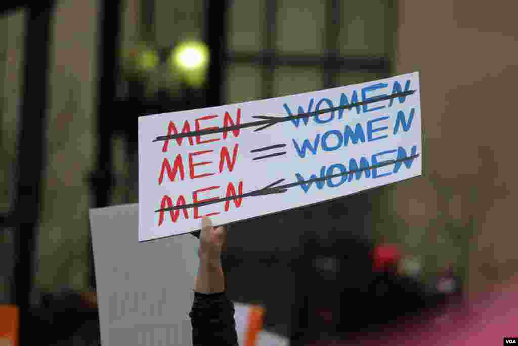 Protesters hold up signs ahead of the Women's March on Washington in downtown Washington, D.C., one day after Donald Trump's inauguration as President of the United States of America. January 21, 2017 (B. Allen / VOA)