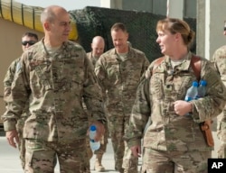 In this image provided by the U.S. Air Force, Lt. Gen. Jeffrey Harrigian, who is currently head of U.S. Air Force's operations throughout the region, walks with Lt. Col. Joy Boston, 455th Expeditionary Operations Support Squadron commander at Bagram Airfi