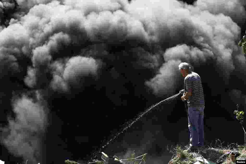 A man tries to extinguish a fire at an illegal garbage dump after residents decided to set fire to it to prevent the spread of the mosquito-borne Zika virus, in a slum of San Jose, Costa Rica, Feb. 8, 2016.