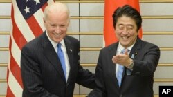 PM Jepang Shinzo Abe (kanan) menyambut Wapres AS Joe Biden sebelum pembicaraan di Tokyo, Selasa (3/12). 