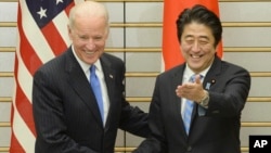 Wapres AS Joe Biden (kiri) dan PM Jepang Shinzo Abe berjabat tangan sebelum pertemuan mereka di Tokyo, Selasa (3/12). 