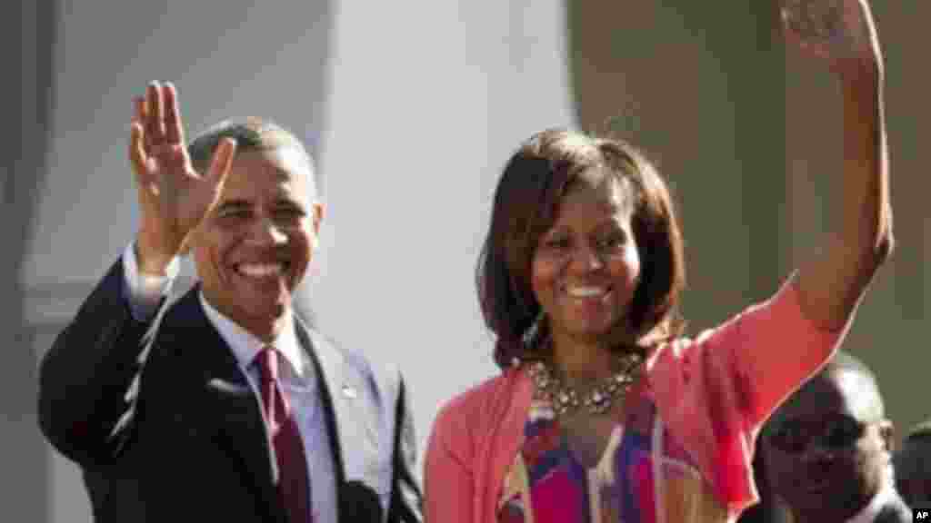 President Obama and first lady Michelle Obama wave as they arrive in Dar es Salaam.