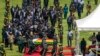 El féretro del expresidente Robert Mugabe, cubierto por la bandera nacional y seguido por familiares y dignatarios, llega para un funeral de Estado al Estadio Nacional Deportivo en Harare, Zimbabue, el sábado.