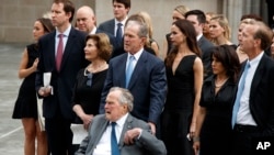 Mantan Presiden George W. Bush dan ayahnya Presiden George H.W. Bush menyaksikan peti jenazah mantan Ibu Negara Barbara Bush dimasukkan ke mobil jenazah di Gereja Episkopal St. Martin, 21 April 2018, di Houston.