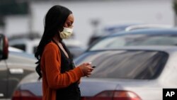 A shopper walks through the Target parking lot in northeast Jackson, Miss., where Mississippi Department of Health released figures show African Americans are being disproportionately affected by the coronavirus