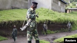 A M23 rebel fighter stands guard as they prepare for withdrawal from Karuba, some 62 kilometers west of Goma, DRC, November 28, 2012. 