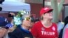 A pro Trump supporter screams across a metal barrier at people protesting the visit to Phoenix by President Donald Trump, Aug. 22, 2017.