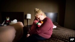 Erica Hail hugs her son Jaxon Maloney, 2, while preparing her older children for their first day of school since the Camp Fire destroyed their home in Yuba City, Calif., Dec. 3, 2018.