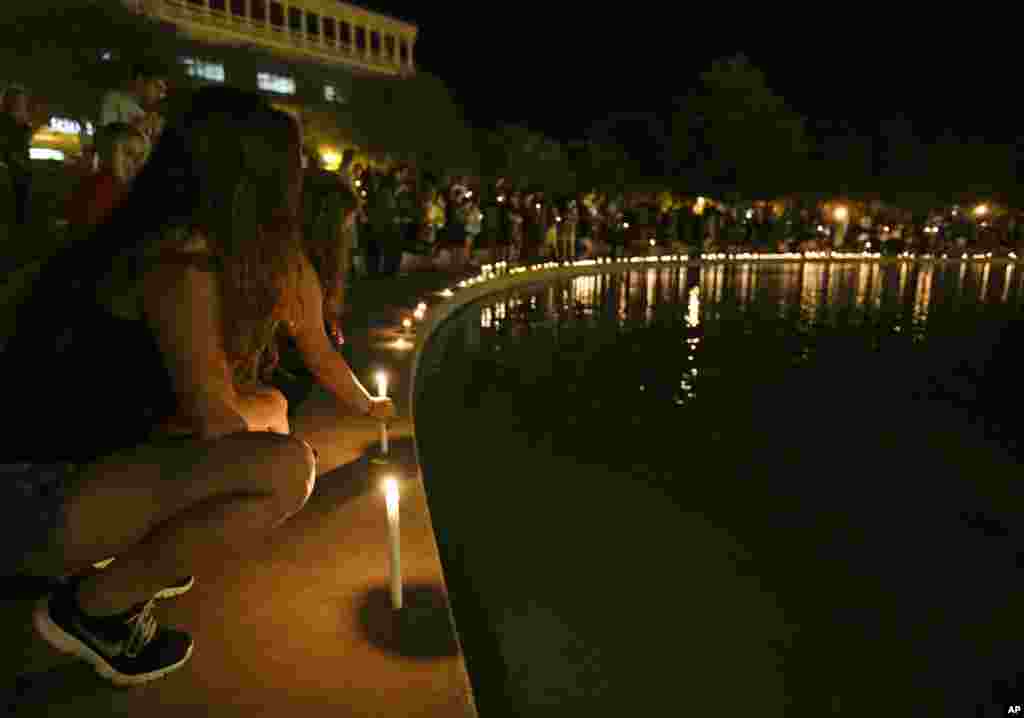 Supporters of Steven Sotloff place candles at the Reflection Pool as they take part in a candle light vigil at the University of Central Florida, in Orlando, Florida, Sept. 3, 2014.
