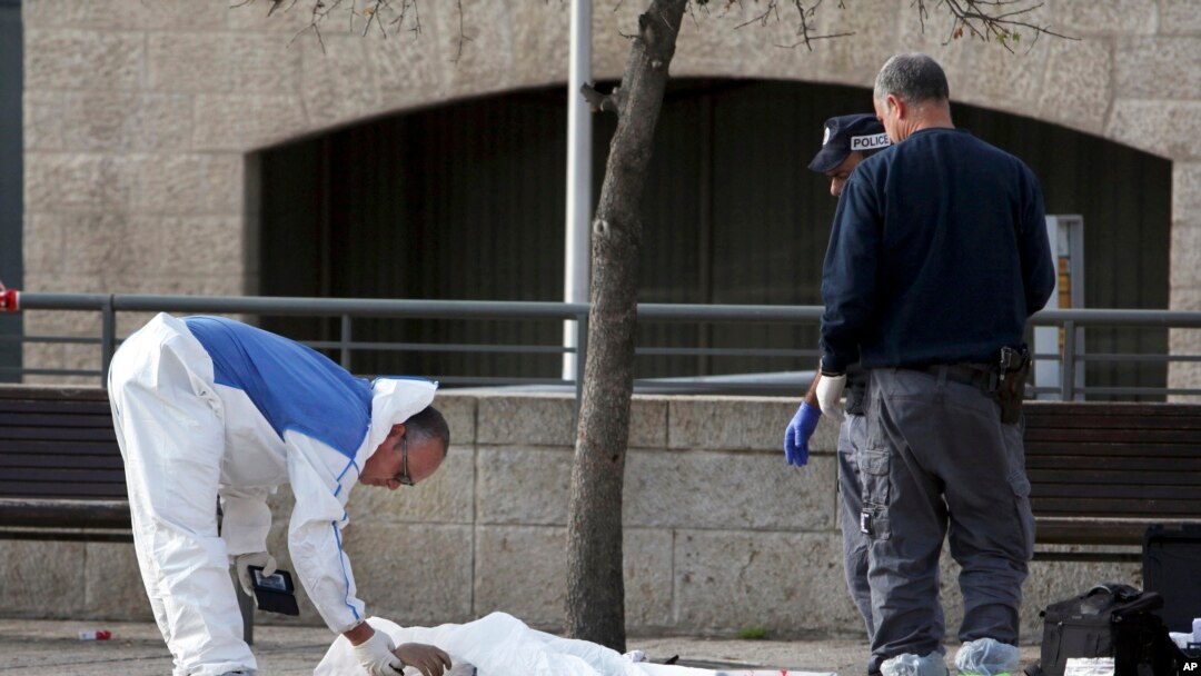 Israeli policemen inspect the body of an alleged Palestinian assailant in Jerusalem, Dec. 26, 2015. 