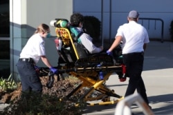 FILE - Emergency medical technicians transport a patient as the spread of the coronavirus infections continues, in Rowland Heights, Los Angeles county, California, Jan. 14, 2021.