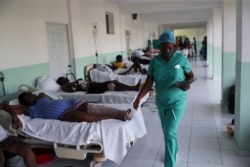 A nurse walks next to beds with people injured by the earthquake on Saturday, at a hospital in Les Cayes, Haiti, August 18, 2021.