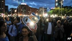 People flash the lights of their mobile phones during a protest outside the government headquarters in Bucharest, Romania, May 12, 2018. Thousands gathered to demonstrate against a judicial overhaul they say will make it harder to prosecute senior officials for graft.