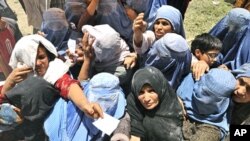 Afghan women stretch for food donations from the World Food Programme (WFP) in Kabul, (File)