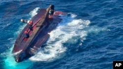 In this photo provided by South Korea Coast Guard, members of South Korean coast guard conduct a search and rescue operation from a capsized boat in waters off Gyeongju, South Korea, Dec. 9, 2024. 