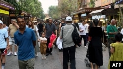 Orang-orang tampak mengunjungi area wisata Old Kashgar di Xinjiang, China, pada 20 Juli 2023. (Foto: AFP/Pedro Pardo)