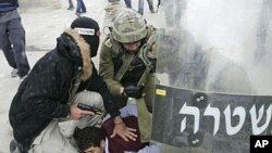 A plainclothes Israeli police officer and soldiers detain a Palestinian protester during clashes near the Qalandiya checkpoint between Ramallah and Jerusalem, Sunday, May 15, 2011